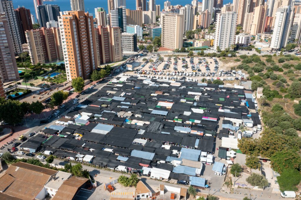 Luftbildaufnahme der Stadt Benidorm in Spain im Sommer mit dem berühmten Markt und den Markthallen mit dem Parkplatz und der belebten Straße neben den Märkten.