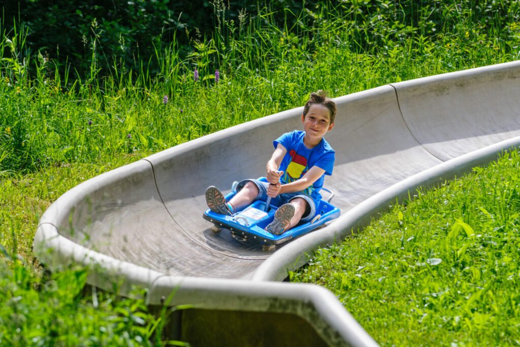 Kleiner Junge ist rasant unterwegs auf einer Sommerrodelbahn